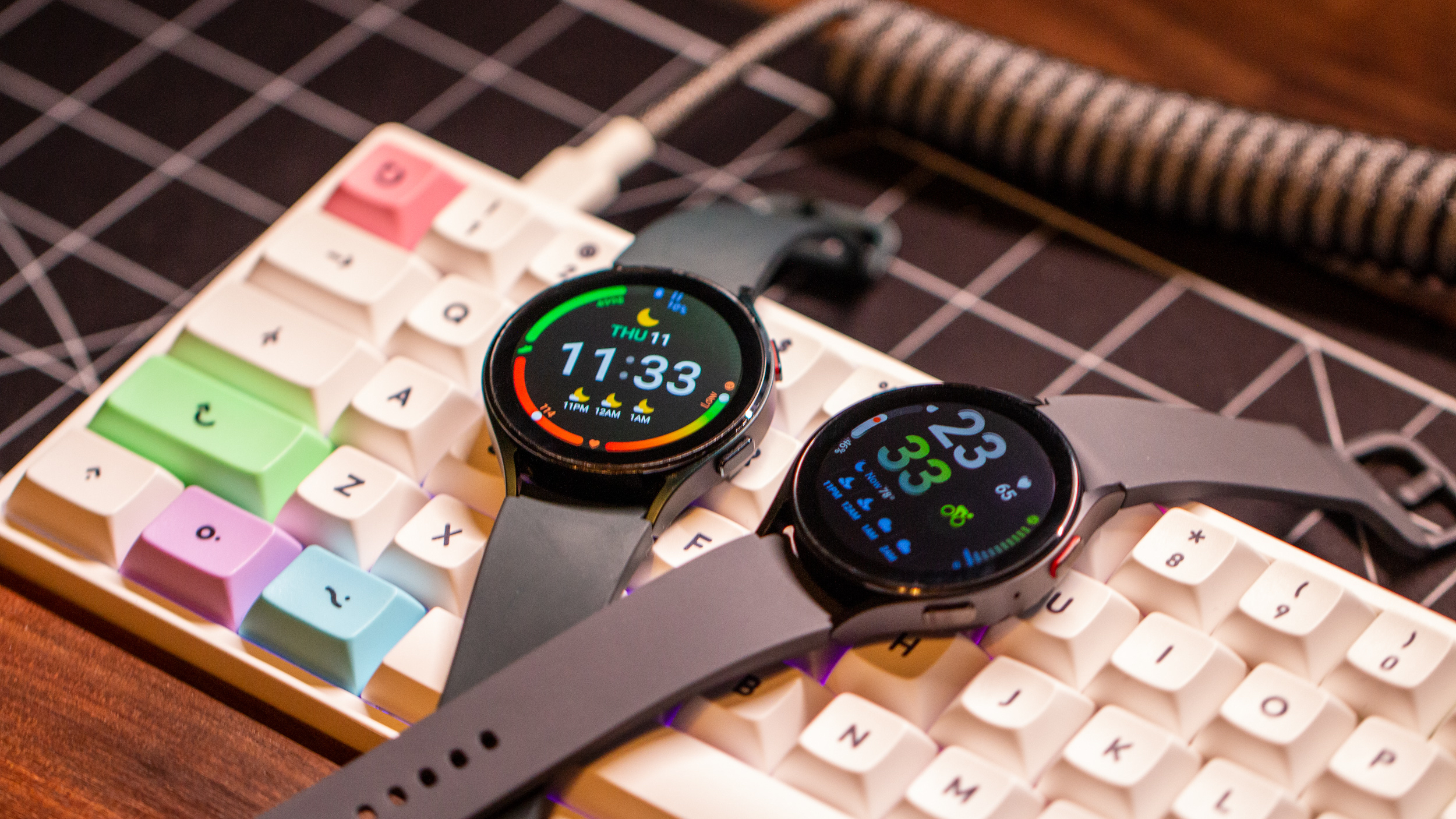 Samsung Galaxy Watch 5 vs Galaxy Watch 4 both screens on sitting atop keyboard